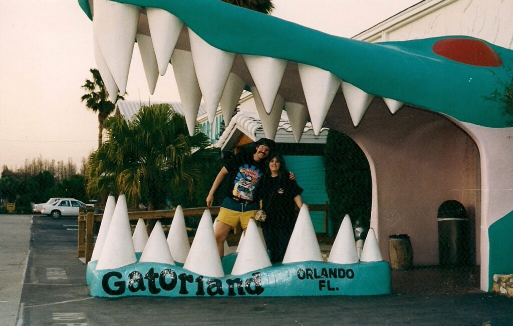 2 people in black t shirts standing in the entrance to Gatorland in Orlando Florida.